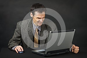 Furious man looks at laptop screen
