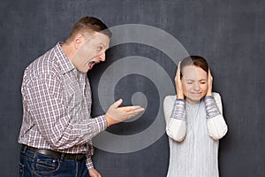 Furious man is screaming on upset woman covering her ears