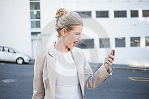Furious stylish businesswoman shouting at her phone