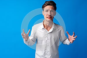 Furious teen guy shouting over blue background