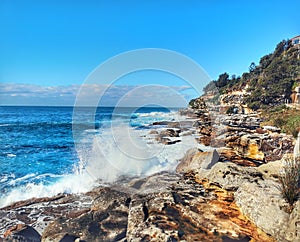 Furious wave hitting the rocks at Bondi Beach