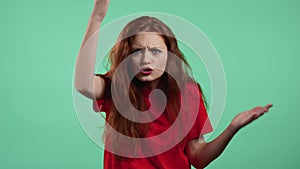 Furious woman on green background. Lady in stress and rage, she threatens with aggression, shouting and looking at