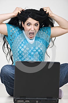 Furious woman with laptop screaming photo