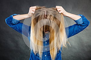 Furious woman pull hair out of head.