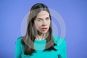 Furious woman on violet background. Lady in stress and rage, she threatens with aggression and looking at camera.