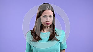Furious woman on violet background. Lady in stress and rage, she threatens with aggression and looking at camera.