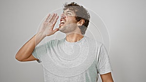 Furious young blond man screams loud in rage, hand on mouth amplifying his voice. captured an isolated white background,