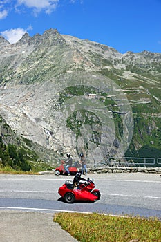 Furka Pass, Switzerland - July 04, 2022: Red scooters in Furka Pass - the canton of Valais, Switzerland, Europe