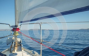 Furling drum at the base of a boat's sail with red rope