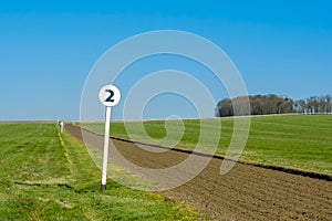 2 furlong distance marker seen on the edge of a professional flat-racing training track.