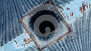 Furnace chimney with traces of soot. Chimney on the roof, covered with old slate. Aerial photography. The camera is down