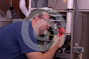 Furnace Tech Examining A Part In A Gas Furnace