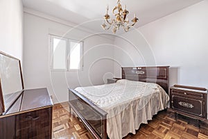 Furnished bedroom with bright wooden bed and side tables in vintage style