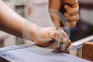 Furniture assembler mechanic works with screwdriver. Male worker installs metal latch. Hands hold repair tool. Small