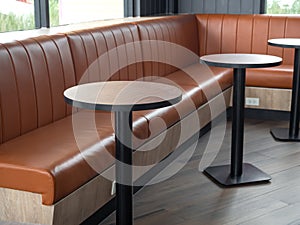 Furniture decoration in cafe retro style. Empty round wood table bars and orange long leather sofa on wood floor