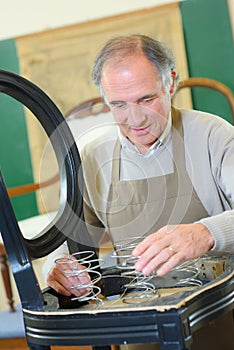 furniture designer working on wooden chair frame