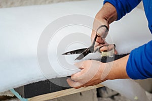 Furniture maker cutting a sofa padding