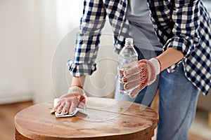 woman degreasing old table surface with solvent