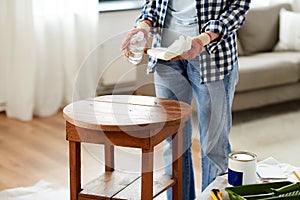 woman degreasing old table surface with solvent