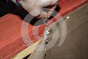 A furniture repair worker replacing the creaking mechanism of an upholstered sofa