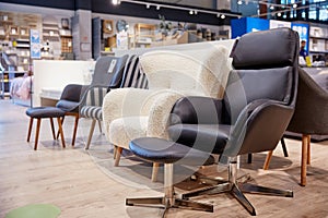 Furniture shop store assortment of modern soft armchair and poof