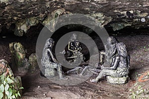 FURONG ZHEN, CHINA - AUGUST 11, 2018: Sculptures of prehistoric people in a cave under the waterfall in Furong Zhen town