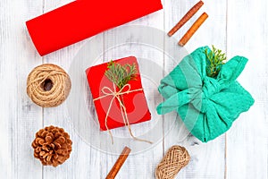 Furoshiki and Christmas gift red box on white wooden background. Hand made
