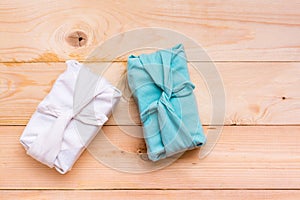 Furoshiki eco-friendly gifts wrapped in cloth on a wooden background. Zero waste. Top view