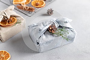 Furoshiki gifts. Christmas presents wrapped in fabric and decorated with natural decor.