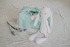 Furoshiki Japanese Gift fabric Wrapping and knitted toy rabbit. Zero waste, eco-friendly gift wrapping box. Fall hand photo