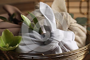 Furoshiki technique. Gifts packed in different fabrics and flowers in bowl, closeup