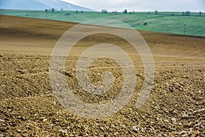 Furrows rows in a plowed field prepared for planting potatoes crops in spring.