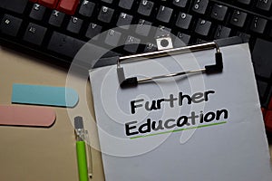 Further Education write on a paperwork isolated on Office Desk