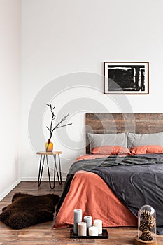 Fury rug on wooden floor of simple bedroom interior