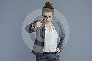 fury woman employee threatening with finger isolated on gray