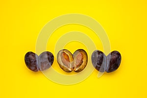 Fused fruits, double prunes. Ugly fruits in row on yellow background, place for text. Food waste reduction. Using in cooking