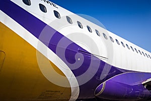 Fuselage of airplane with door and windows. Row of portholes outside the passenger aircraft. Plane on bly sky background