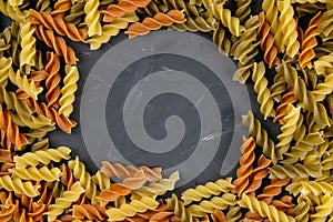 Fusili pasta. Closeup of raw fusilli macaroni in spiral shape with empty middle for messages. On a granite background. Top views