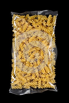 Fusili pasta in plastic package isolated in black background.