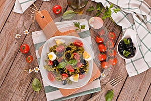 Fusilli pasta with cherry tomatoes, eggs and black olives.