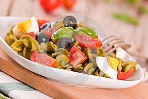 Fusilli pasta with cherry tomatoes, eggs and black olives.