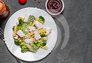 Fusilli pasta with chicken breast and broccoli salad in white plate