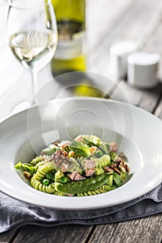 Fusilli pasta with green peas ham walnuts with white wine. italian or mediterranean cuisine