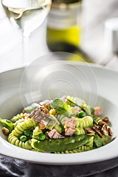 Fusilli pasta with green peas ham walnuts with white wine. italian or mediterranean cuisine