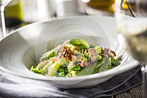 Fusilli pasta with green peas ham walnuts with white wine. italian or mediterranean cuisine