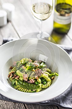 Fusilli pasta with green peas ham walnuts with white wine. italian or mediterranean cuisine