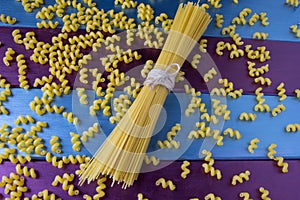 Fusilly pasta and a bunch of spaghetti at bright colorful background