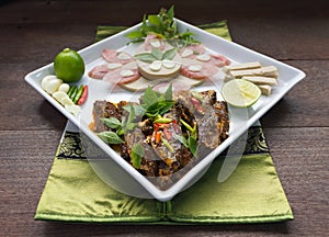 Fusion menu fried mackerel fish and chilli sauce decorated with Vietnamese ham and sliced fermented pork sausage