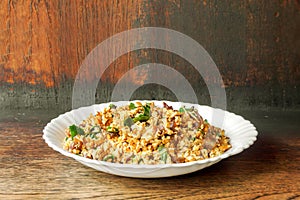 Fusion vegan food in Thai northern style Larp in white ceramic plate on wooden background.