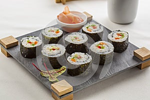 Futomaki served on a slate tray with ginger.